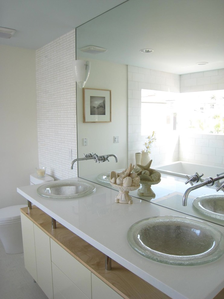 Inspiration for a beach style bathroom in Los Angeles with a drop-in sink, flat-panel cabinets, beige cabinets, engineered quartz benchtops, a drop-in tub, a one-piece toilet and white tile.