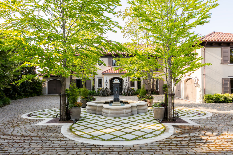 This is an example of a mediterranean front yard driveway in Seattle with a water feature.