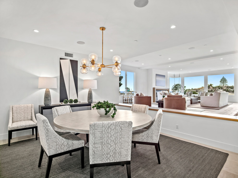 Mid-sized contemporary open plan dining in Orange County with white walls, limestone floors and beige floor.