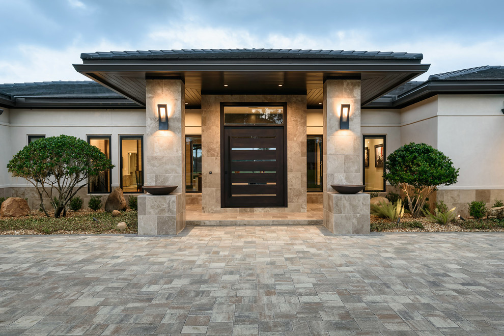This is an example of a large asian front door in Jacksonville with beige walls, limestone floors, a pivot front door, a dark wood front door and grey floor.