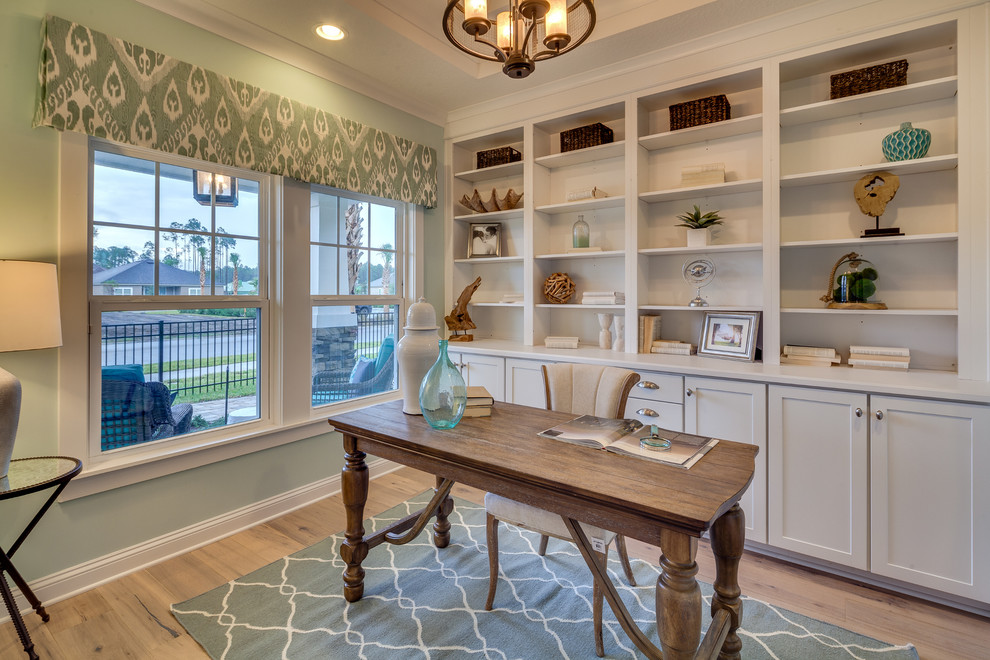 Photo of a beach style study room in Jacksonville with green walls, light hardwood floors and a freestanding desk.