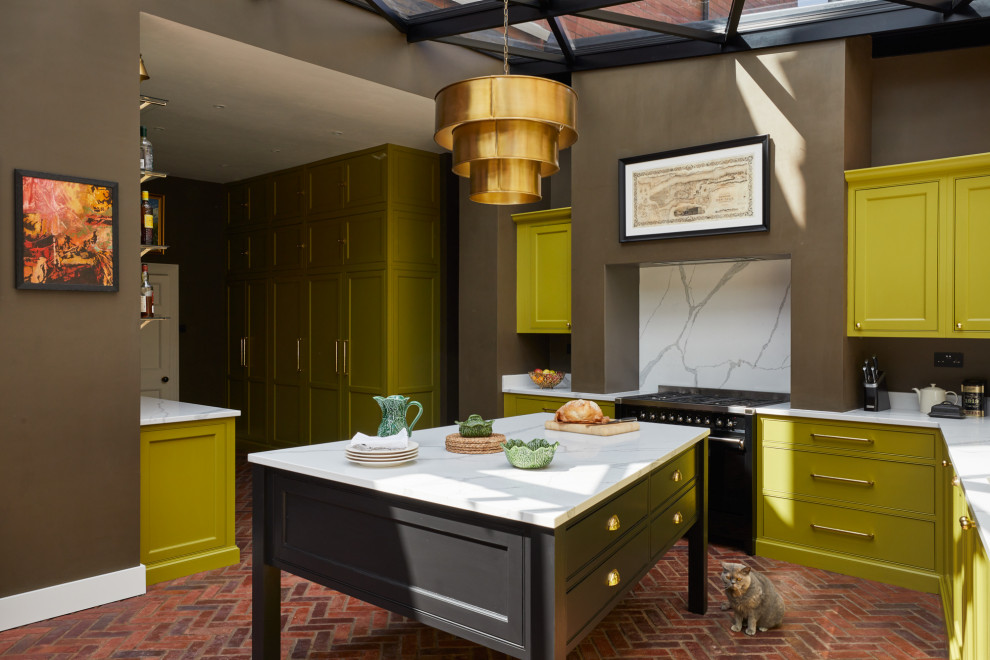 Foto på ett stort funkis vit kök, med en nedsänkt diskho, skåp i shakerstil, gröna skåp, bänkskiva i kvartsit, grönt stänkskydd, stänkskydd i tegel, integrerade vitvaror, tegelgolv, en köksö och brunt golv
