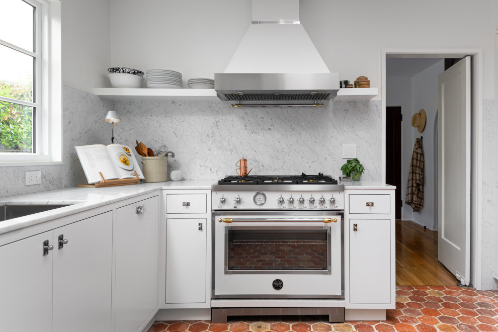 Foto de cocina urbana con armarios con paneles lisos, puertas de armario blancas, encimera de mármol y suelo de baldosas de terracota