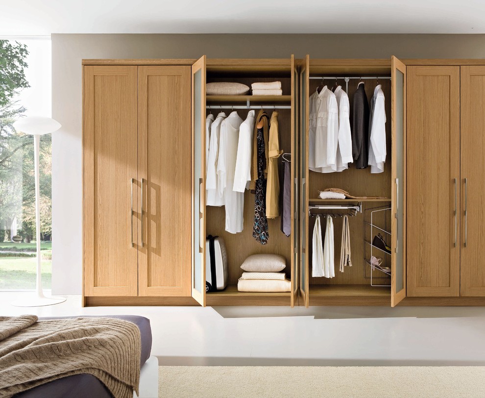 Inspiration for a contemporary gender-neutral storage and wardrobe in Dublin with recessed-panel cabinets and medium wood cabinets.