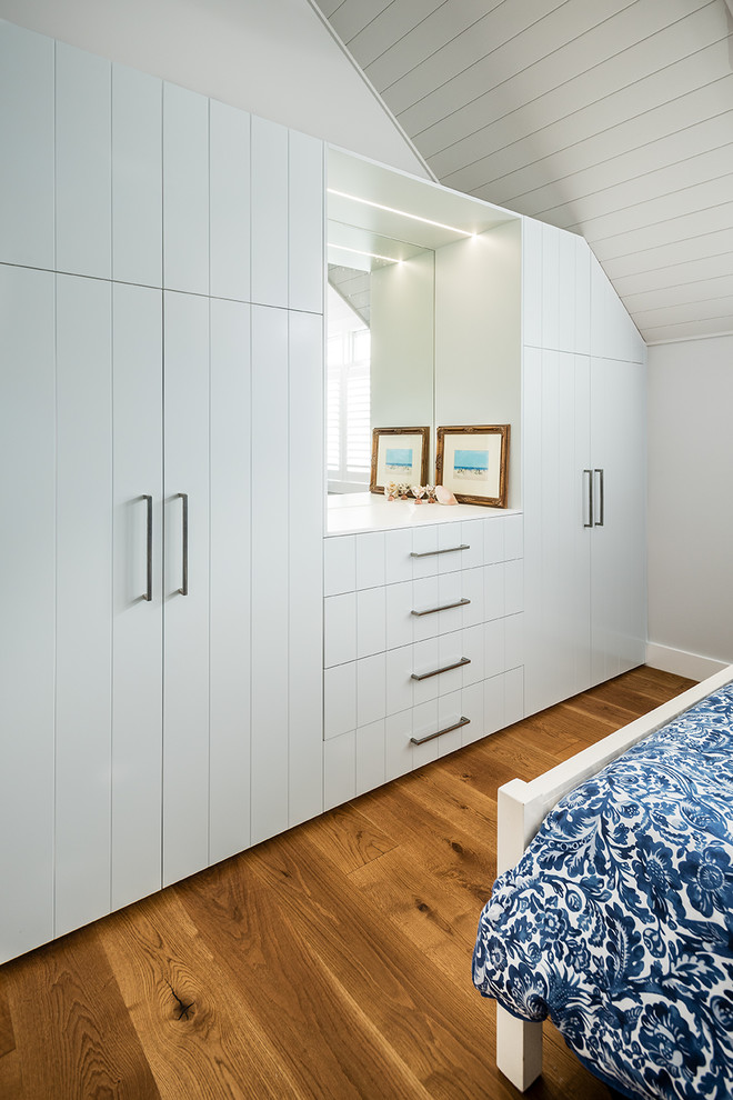 Inspiration for a mid-sized beach style gender-neutral dressing room in Melbourne with flat-panel cabinets, grey cabinets, dark hardwood floors and brown floor.