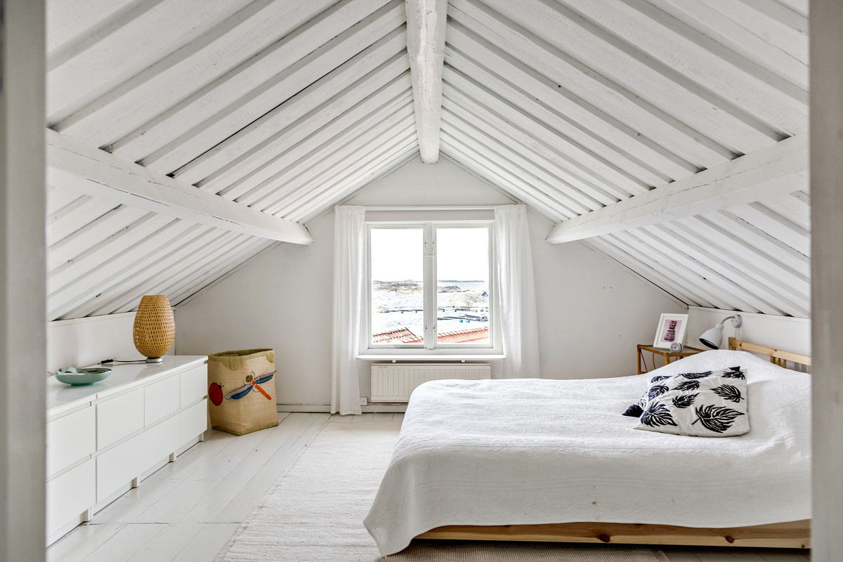 Beach style bedroom in Gothenburg with white walls, light hardwood floors and white floor.