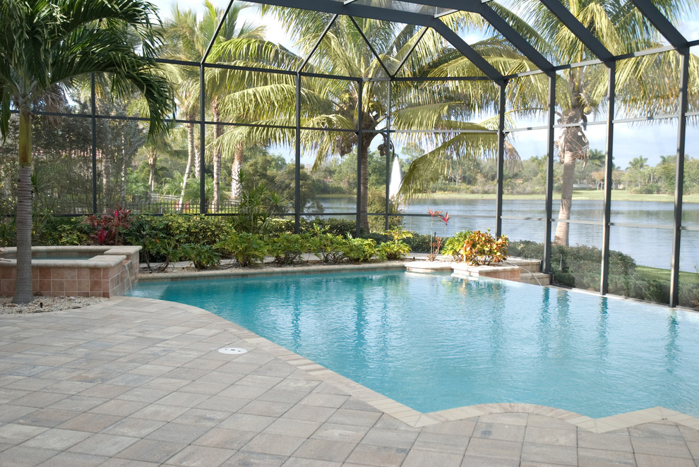 Design ideas for a large tropical backyard custom-shaped infinity pool in Other with a hot tub and tile.