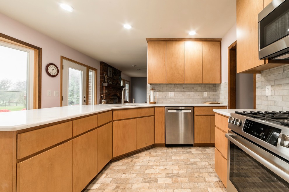 Eat-in kitchen - mid-sized transitional l-shaped ceramic tile and multicolored floor eat-in kitchen idea in Chicago with an undermount sink, flat-panel cabinets, light wood cabinets, quartz countertops, multicolored backsplash, ceramic backsplash, stainless steel appliances, a peninsula and multicolored countertops