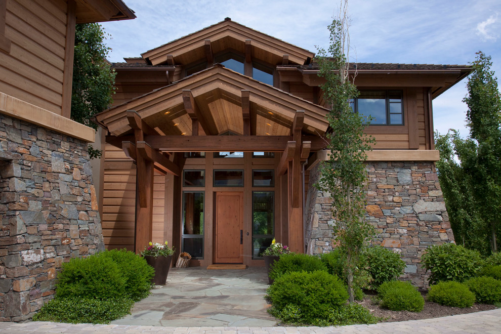 This is an example of an expansive arts and crafts three-storey brown exterior in Seattle with stone veneer.