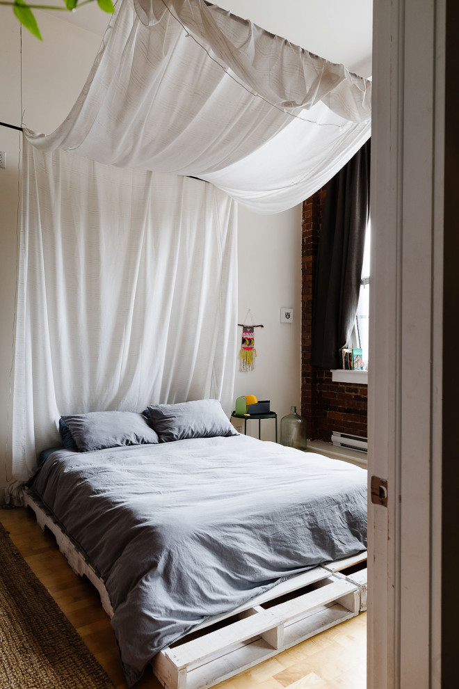 Пример оригинального дизайна: большая спальня в стиле фьюжн с белыми стенами, светлым паркетным полом и кирпичными стенами