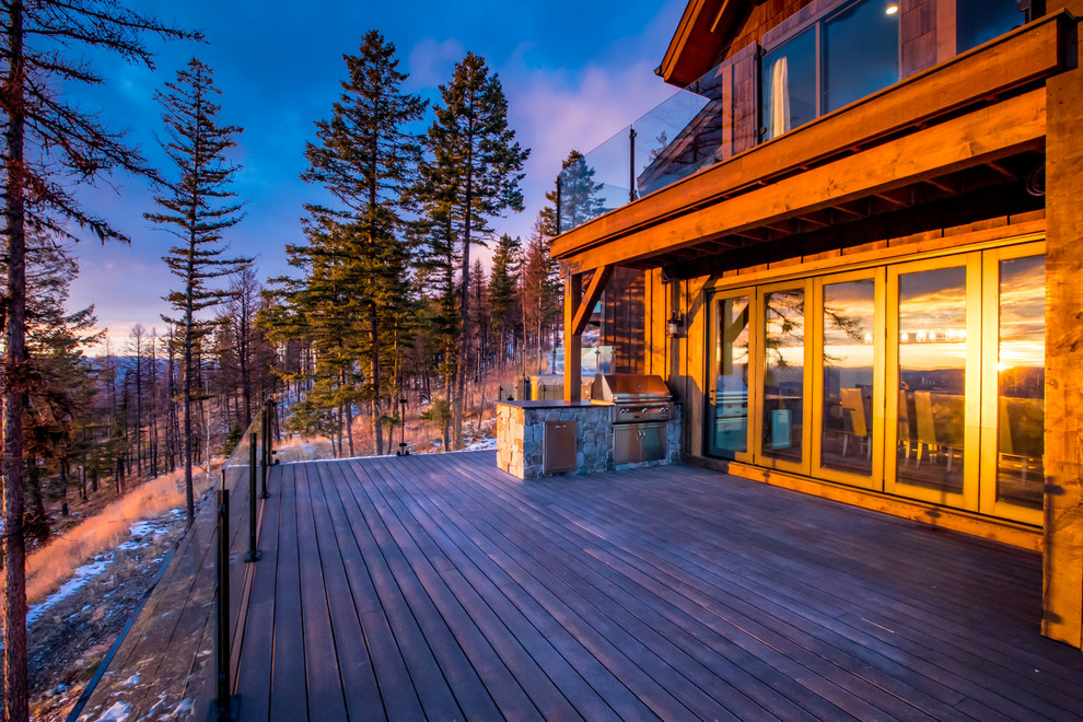 Example of a large mountain style backyard deck design with a fire pit and no cover