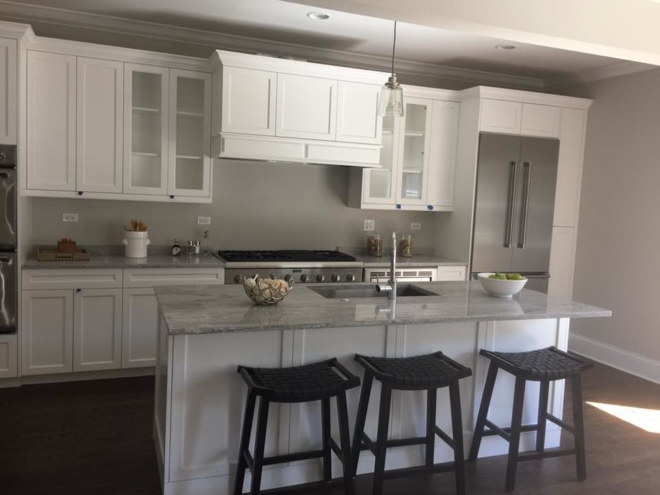Inspiration for a mid-sized transitional single-wall kitchen remodel in Chicago with a single-bowl sink, shaker cabinets, white cabinets, granite countertops, stainless steel appliances and an island