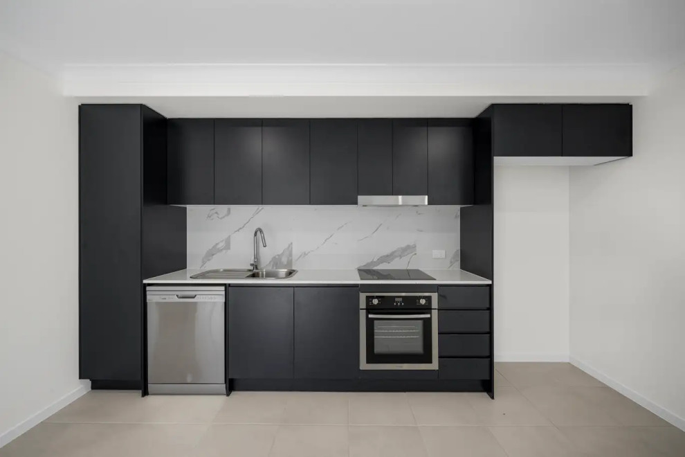 This is an example of a small contemporary single-wall eat-in kitchen in Sydney with a single-bowl sink, flat-panel cabinets, black cabinets, marble benchtops, multi-coloured splashback, marble splashback, stainless steel appliances, ceramic floors, no island, grey floor and multi-coloured benchtop.