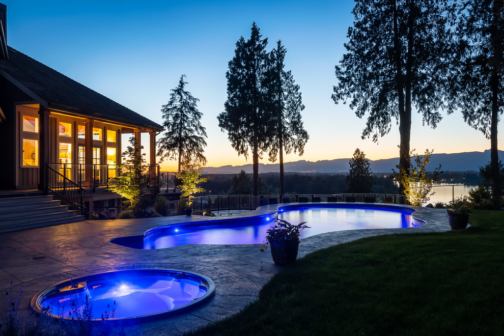 Design ideas for a large contemporary custom-shaped pool in Vancouver with stamped concrete.