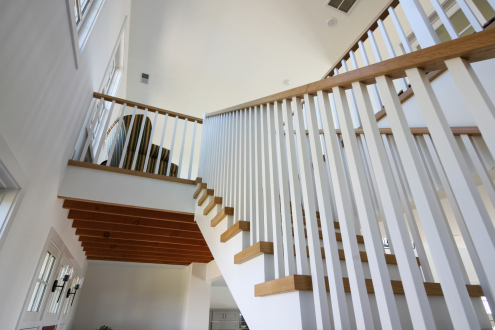 Photo of a medium sized farmhouse wood u-shaped wood railing staircase in DC Metro with wood risers and tongue and groove walls.