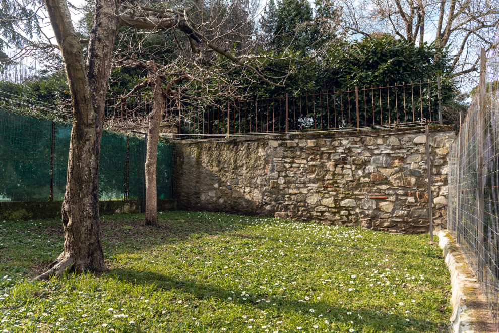 Пример оригинального дизайна: маленький участок и сад зимой на заднем дворе в стиле рустика с подпорной стенкой, полуденной тенью, покрытием из каменной брусчатки и с металлическим забором для на участке и в саду