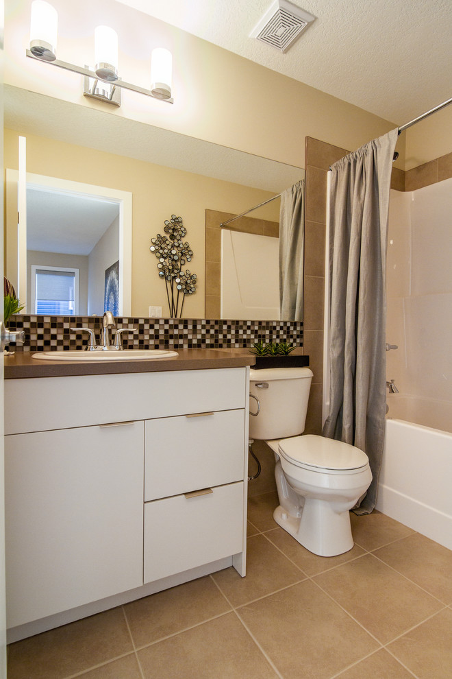 Mid-sized contemporary bathroom in Calgary with a drop-in sink, flat-panel cabinets, white cabinets, laminate benchtops, an alcove tub, a shower/bathtub combo, a two-piece toilet, beige walls, ceramic floors, multi-coloured tile, glass tile and a shower curtain.