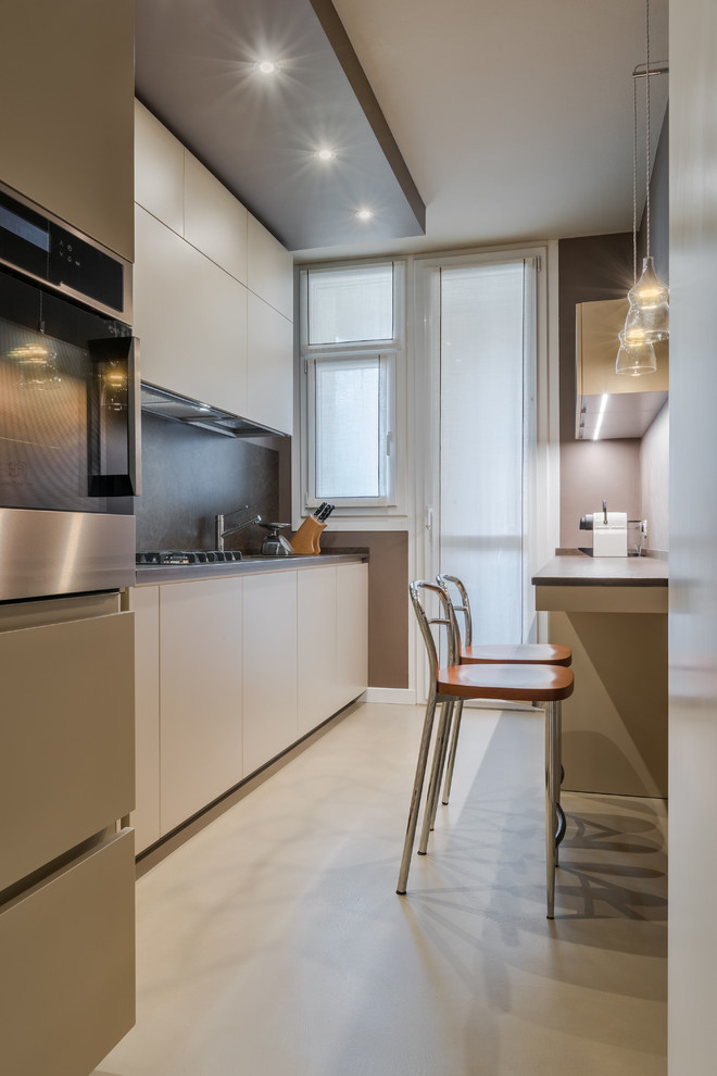 Photo of a mid-sized contemporary kitchen in Milan with flat-panel cabinets, beige cabinets, black splashback, stainless steel appliances, no island and beige floor.