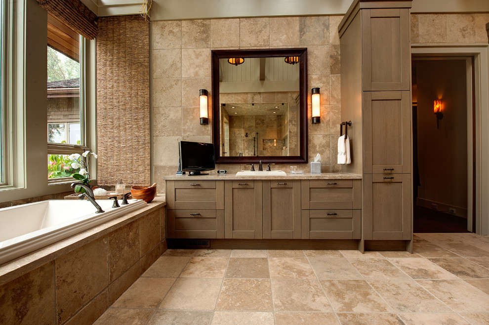 Country bathroom in Atlanta with a drop-in sink, shaker cabinets, medium wood cabinets, a drop-in tub and beige tile.