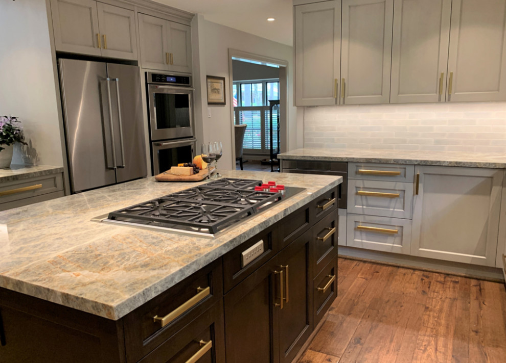 Design ideas for an expansive modern u-shaped open plan kitchen in Houston with an undermount sink, shaker cabinets, grey cabinets, quartzite benchtops, grey splashback, porcelain splashback, stainless steel appliances, light hardwood floors, with island, brown floor and blue benchtop.