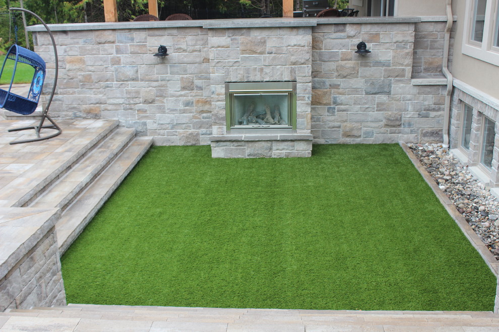 Large contemporary backyard patio in Ottawa with a fire feature, stamped concrete and a pergola.