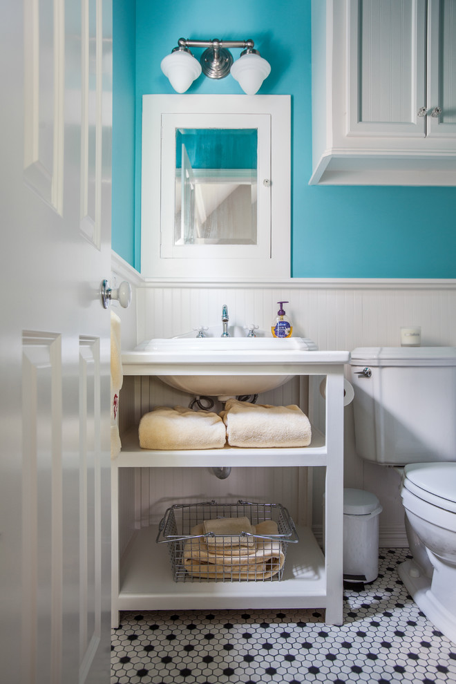 This is an example of a large traditional kids bathroom in Houston with a drop-in sink, open cabinets, white cabinets, a two-piece toilet, blue walls, solid surface benchtops, a drop-in tub, a shower/bathtub combo, multi-coloured tile, porcelain tile and mosaic tile floors.