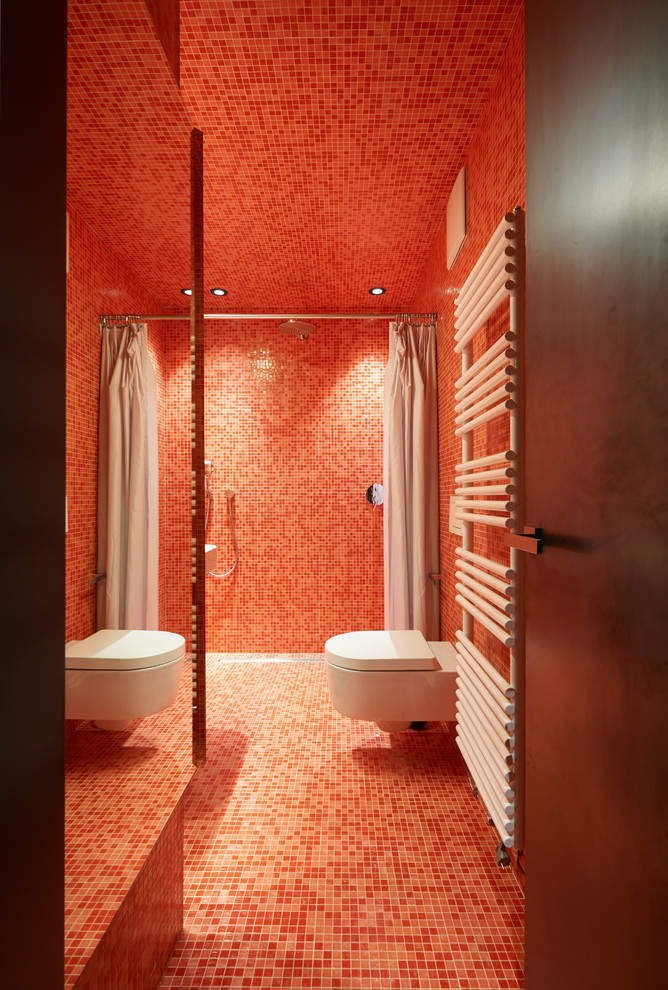 Photo of a contemporary 3/4 bathroom in Other with a curbless shower, a wall-mount toilet, red tile, mosaic tile, red walls, mosaic tile floors, red floor and a shower curtain.