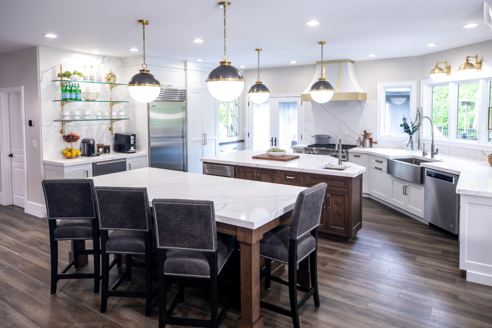 Eat-in kitchen - transitional medium tone wood floor and brown floor eat-in kitchen idea with a farmhouse sink, shaker cabinets, white cabinets, quartz countertops, white backsplash, quartz backsplash, stainless steel appliances, two islands and white countertops