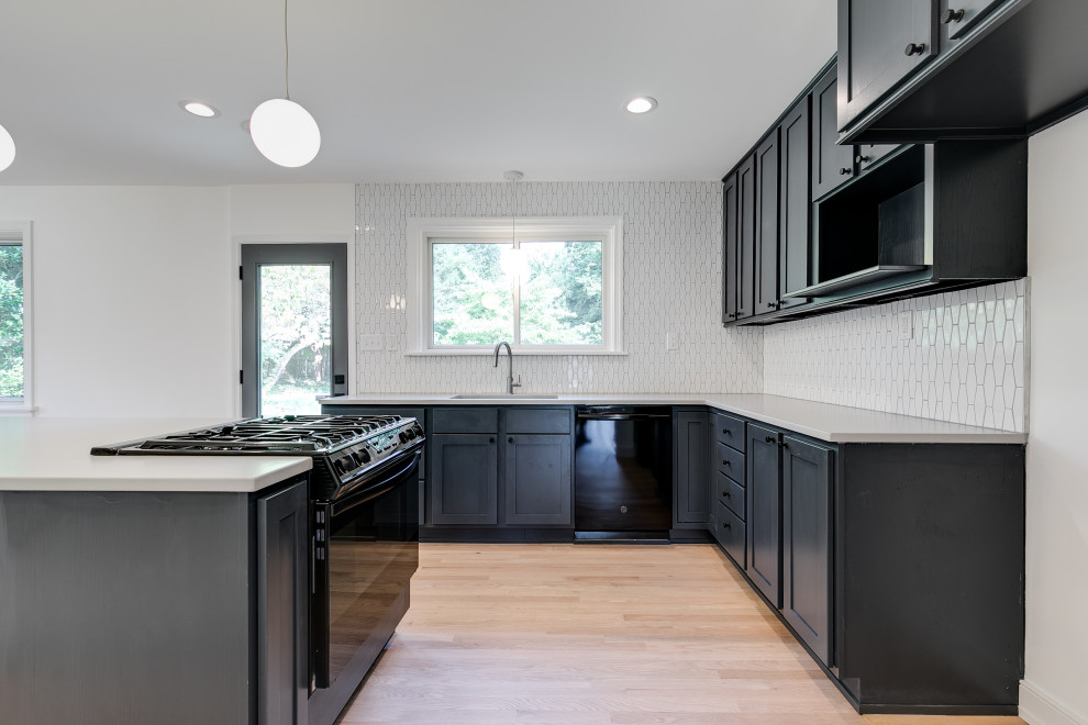 Esempio di una cucina minimalista di medie dimensioni con ante con bugna sagomata, ante nere, paraspruzzi bianco, paraspruzzi con piastrelle in ceramica e top bianco