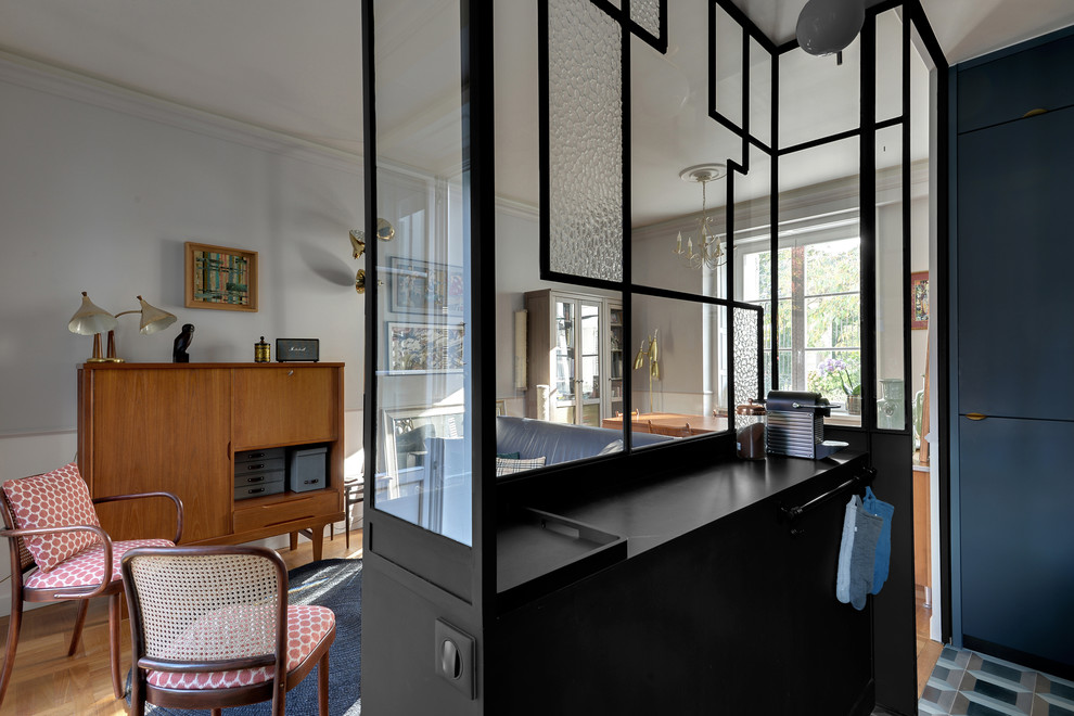 Small transitional galley eat-in kitchen in Paris with a drop-in sink, beaded inset cabinets, blue cabinets, tile benchtops, black splashback, ceramic splashback, black appliances, cement tiles, no island and blue floor.
