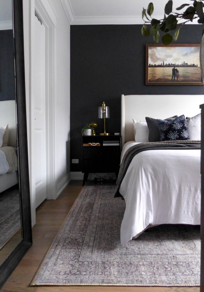 Inspiration for a small master bedroom in Chicago with black walls, medium hardwood floors, no fireplace and brown floor.