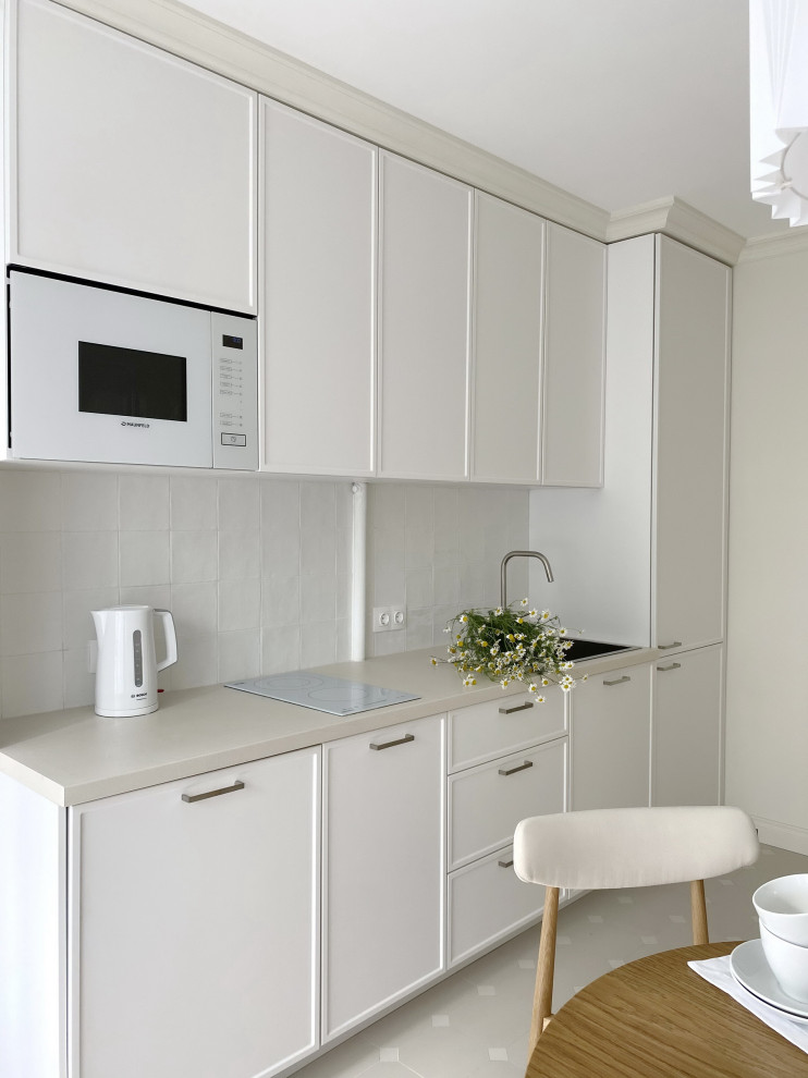 Inspiration for a small single-wall separate kitchen in Moscow with a drop-in sink, beaded inset cabinets, white cabinets, laminate benchtops, white splashback, ceramic splashback, white appliances, porcelain floors, no island, beige floor and beige benchtop.
