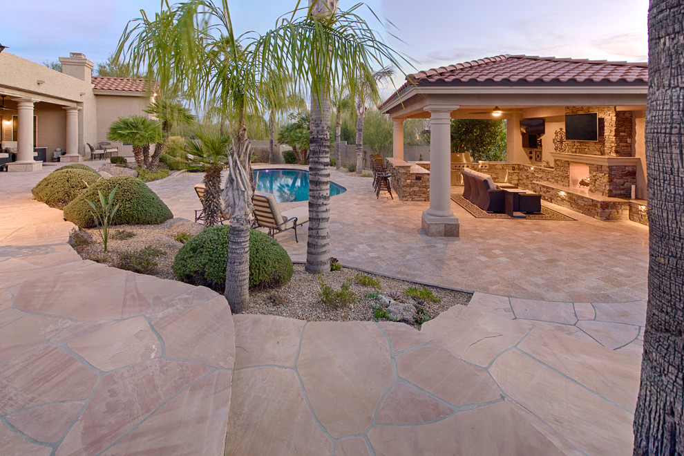 Photo of a large mediterranean backyard natural pool in Phoenix with concrete pavers.