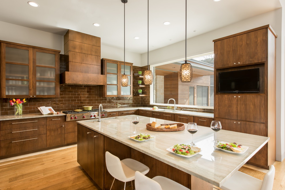 Design ideas for a large contemporary u-shaped eat-in kitchen in Austin with flat-panel cabinets, medium wood cabinets, quartzite benchtops, brown splashback, light hardwood floors, with island, an undermount sink, subway tile splashback, panelled appliances and brown floor.