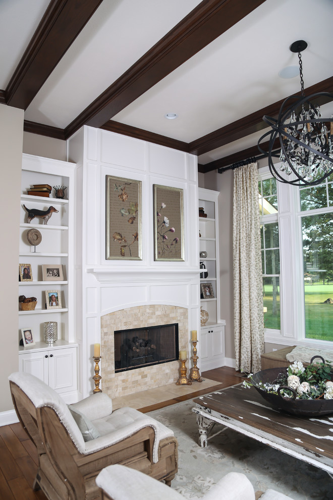 Photo of a mid-sized country formal open concept living room in Indianapolis with grey walls, medium hardwood floors, a standard fireplace, a tile fireplace surround, no tv and brown floor.