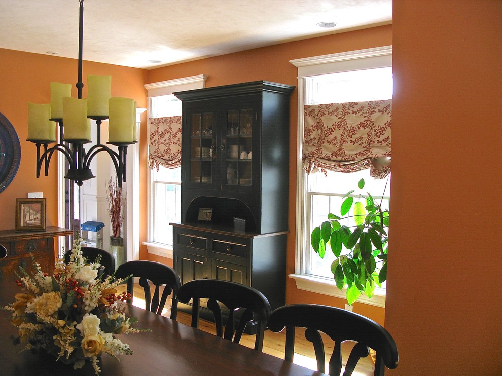 Inspiration for a mid-sized traditional separate dining room in Other with orange walls and light hardwood floors.