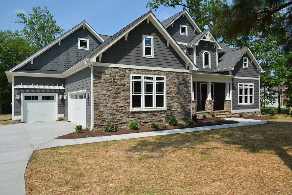 This is an example of an expansive arts and crafts two-storey grey house exterior in Raleigh with mixed siding, a gable roof and a shingle roof.