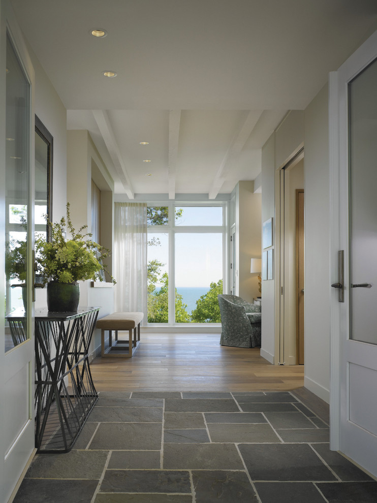 This is an example of a large transitional hallway in Other with white walls and ceramic floors.