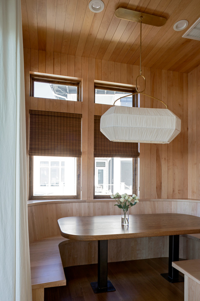Cette photo montre une salle à manger bord de mer en bois de taille moyenne avec une banquette d'angle, un mur marron, un sol en bois brun, un sol marron et un plafond en bois.