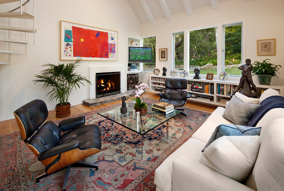 Photo of a contemporary open concept family room in Santa Barbara with white walls, medium hardwood floors, a standard fireplace and a plaster fireplace surround.