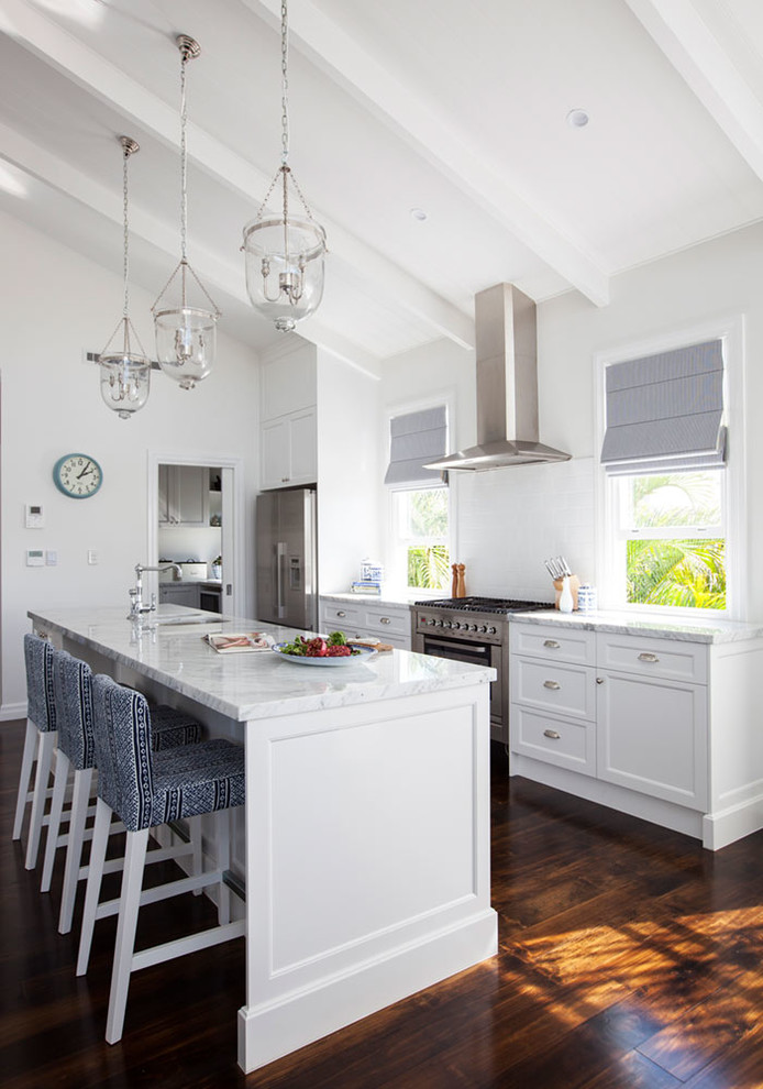 Mid-sized beach style galley eat-in kitchen in Brisbane with white cabinets, marble benchtops, stainless steel appliances, dark hardwood floors and with island.
