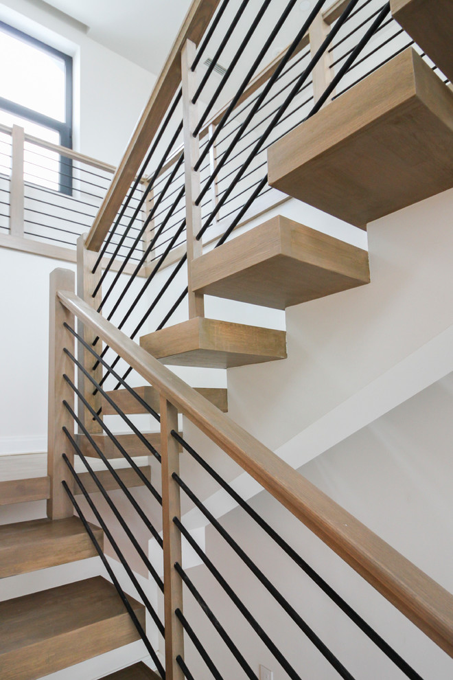 Large contemporary wood u-shaped staircase in DC Metro with cable railing.
