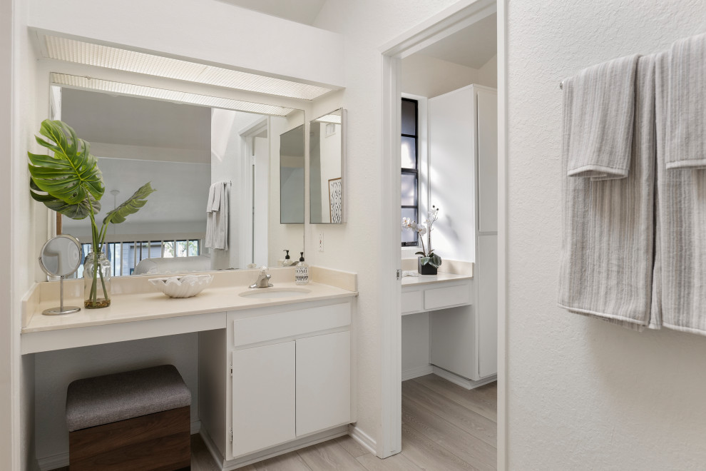Idéer för ett litet modernt beige en-suite badrum, med släta luckor, vita skåp, en dusch i en alkov, vita väggar, ljust trägolv, ett undermonterad handfat, bänkskiva i kvarts och dusch med skjutdörr