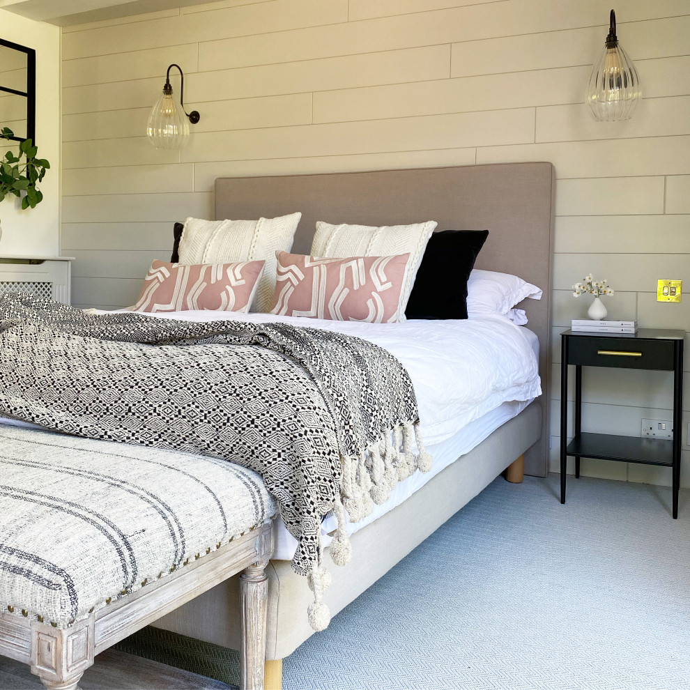 Scandinavian master bedroom in Surrey with white walls and panelled walls.