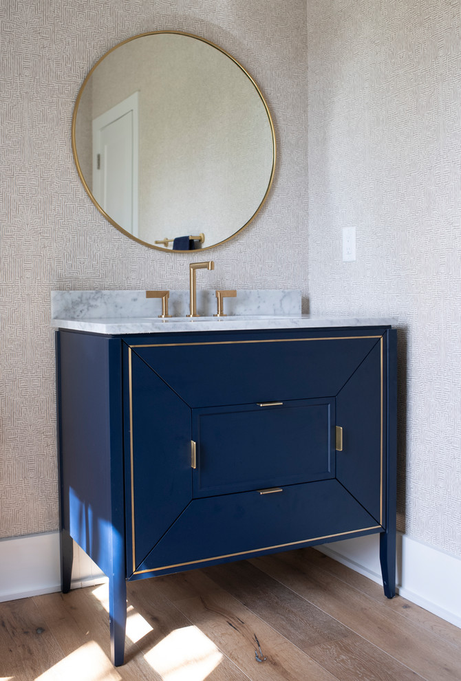 Design ideas for a medium sized traditional cloakroom in Charleston with freestanding cabinets, blue cabinets, beige walls, light hardwood flooring, a submerged sink, marble worktops, brown floors, multi-coloured worktops, a freestanding vanity unit and wallpapered walls.