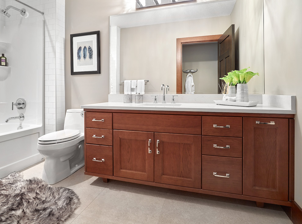 Example of a transitional kids' white tile drop-in bathtub design in Edmonton with recessed-panel cabinets, medium tone wood cabinets, gray walls, a drop-in sink and quartz countertops