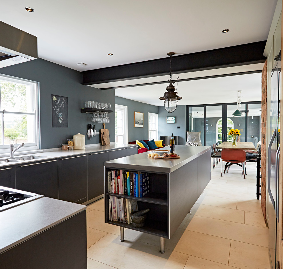 Photo of a large eclectic galley open plan kitchen in Devon with flat-panel cabinets, grey cabinets, stainless steel benchtops, metallic splashback, with island, an integrated sink, stainless steel appliances, porcelain floors and beige floor.