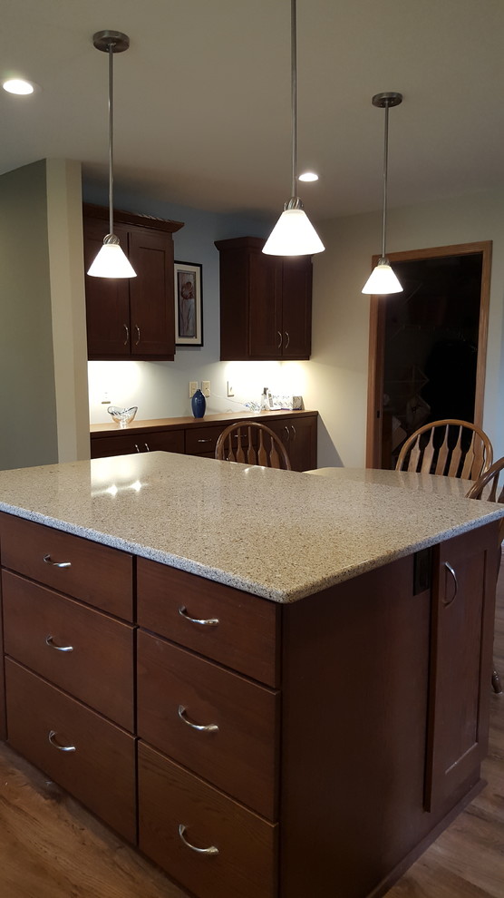 Example of a large transitional l-shaped vinyl floor eat-in kitchen design with an undermount sink, shaker cabinets, dark wood cabinets, quartz countertops, beige backsplash, subway tile backsplash, stainless steel appliances and an island