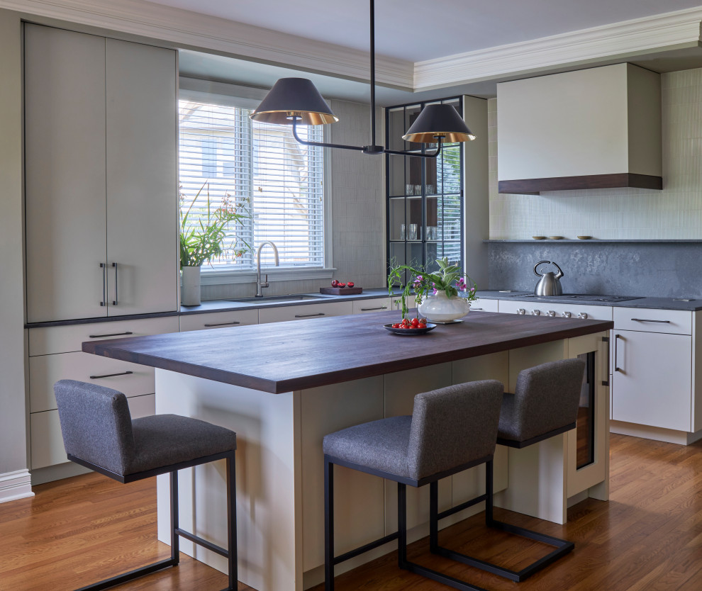 Inspiration for a medium sized modern kitchen in Chicago with a single-bowl sink, flat-panel cabinets, white cabinets, wood worktops, medium hardwood flooring, an island, brown floors and grey worktops.