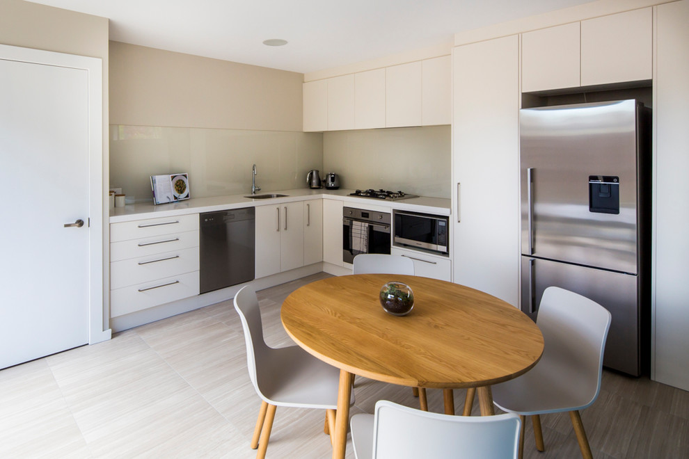 Inspiration for a small contemporary l-shaped eat-in kitchen in Christchurch with no island, an undermount sink, glass sheet splashback, stainless steel appliances, ceramic floors and multi-coloured floor.
